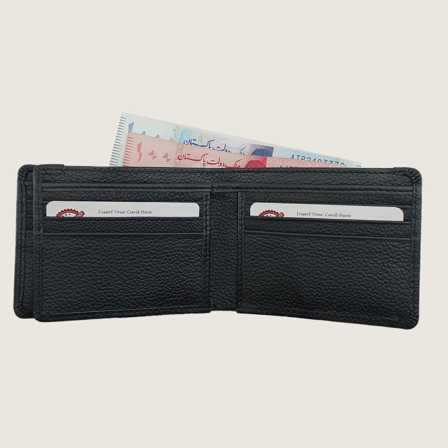 A black pebbled leather bifold wallet shown open, with two card slots containing sample credit cards and banknotes visible above, on a light beige background.