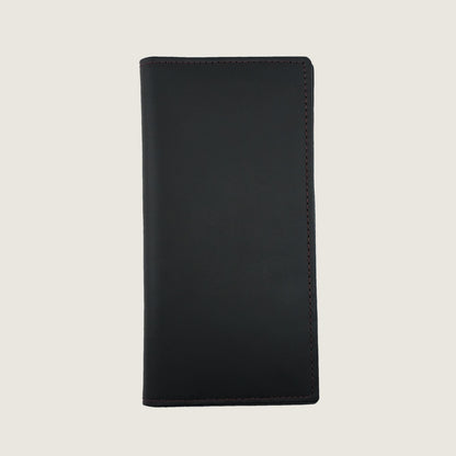 A minimalist black leather passport cover  with clean stitching, shown flat against a light beige background.