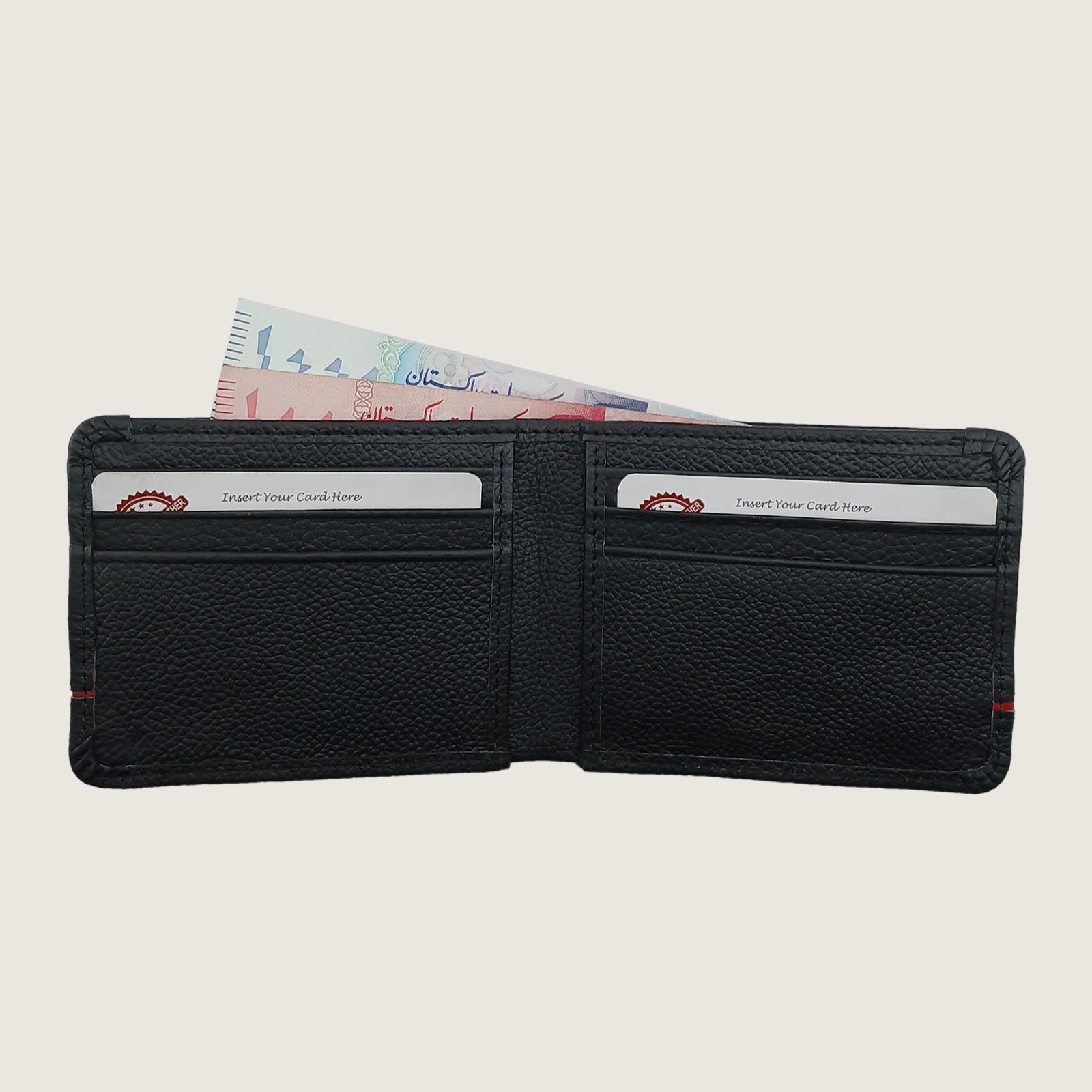A black textured leather bi-fold wallet shown open, with two card slots containing sample credit cards and a banknote tucked inside, on a light beige background.