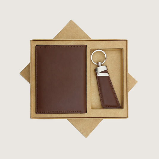 A brown leather wallet and matching keychain presented in a kraft paper gift box on a light beige background.