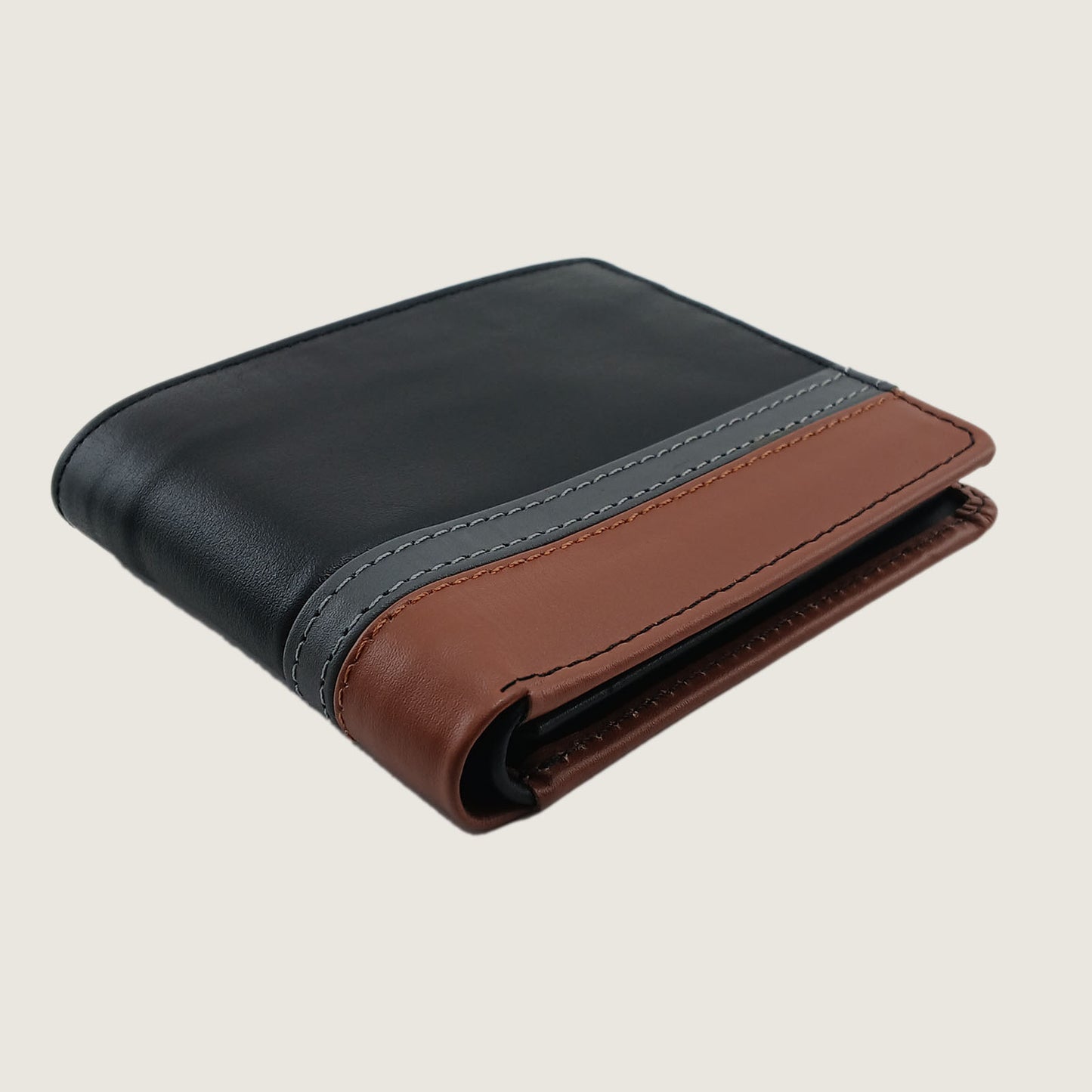 A bi-fold wallet made of leather with a black upper section, a brown lower section, and a gray center stripe with matching stitching, shown on a light beige background.