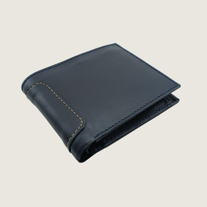 A dark navy blue leather bifold wallet with light beige contrast stitching, shown closed on a light beige background.