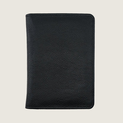A black pebbled leather passport cover or document holder, shown closed from the front against a light beige background.