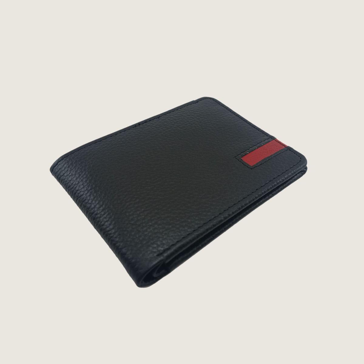 Black pebbled leather bifold wallet with a small red rectangular accent tab on the upper right corner, shown on a light beige background.